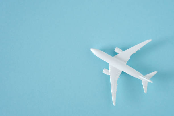 istock White airplane on blue background, top view 1308160017