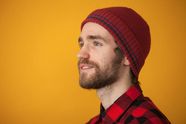 Bearded man wear hat with ear flaps red background. Soft furry accessory. Caring fur garments. Bearded funny hipster. Winter fashion concept. Warm hat for cold weather. Sheep fur. Perfect accessory.