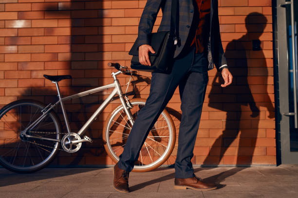 istock Crop businessman walking near brick wall and bicycle 1308167614