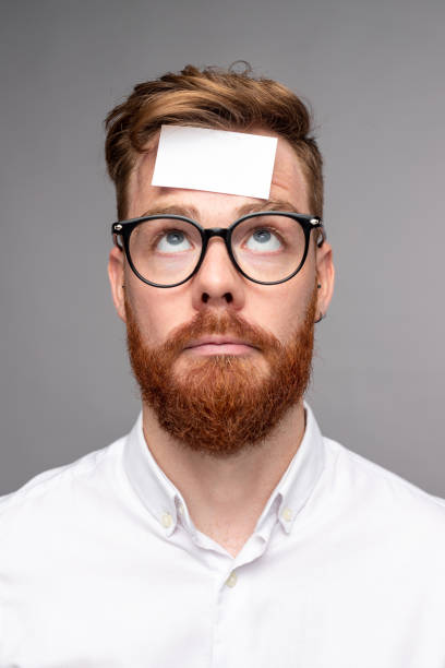 uomo perplesso con adesivo sulla fronte - vertical caucasian glasses red hair foto e immagini stock