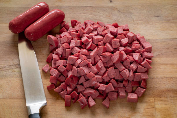 Sausage with knife over cutting board stock photo