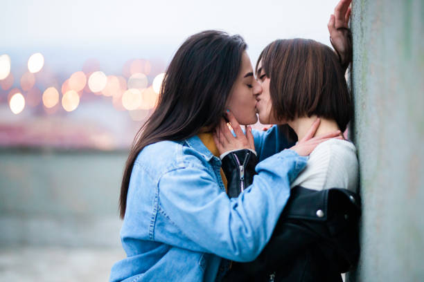 Young female lgbt couple kissing Young lgbt couple embracing and enjoying. Lgbt couple enjoys in spending time together kissing on the mouth stock pictures, royalty-free photos & images