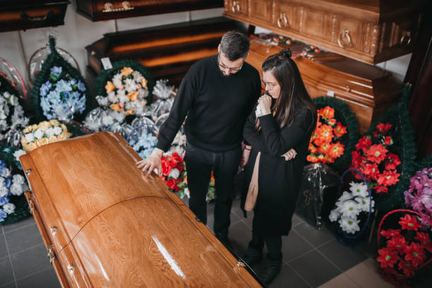Undertaker showing coffins and crosses to a widow Undertaker showing coffins and crosses to a widow coffin photos stock pictures, royalty-free photos & images