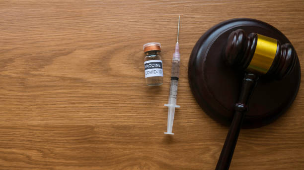law and vaccination concept. top view of bottle of covid-19 vaccine, gavel and syringe on wooden background with copy space. - gavel mallet law legal system imagens e fotografias de stock