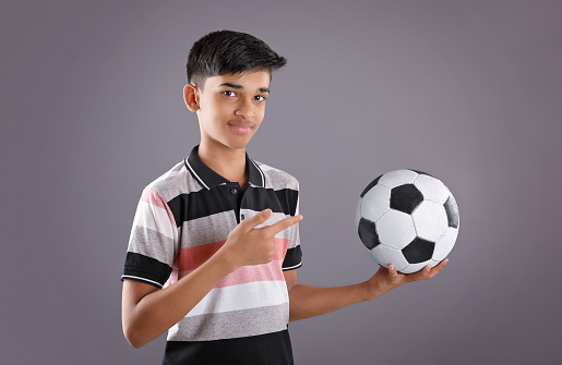 Trophy, football and winning children celebrate on field for achievement, teamwork or victory. Soccer, celebration award or happiness of kids with sports success, team reward or competition champions