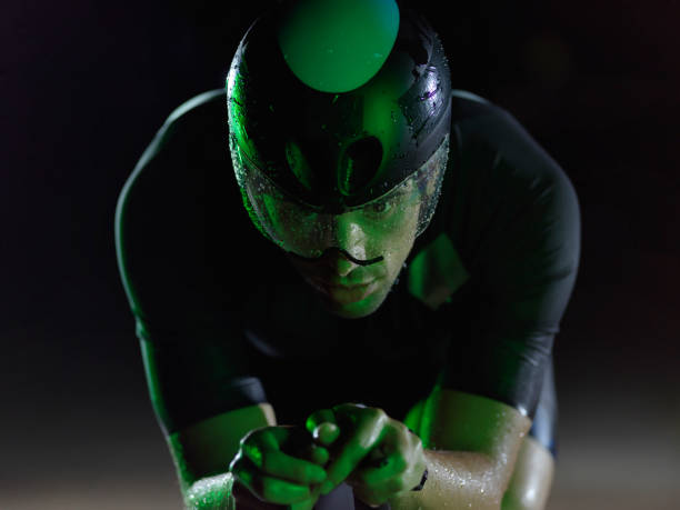 istock triathlon athlete riding bike at night 1308181540