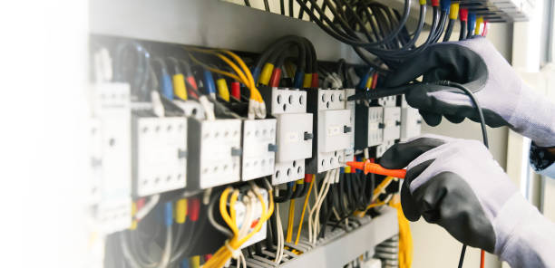 istock Electrical engineers test electrical installations and wiring on protective relays, measuring them with a multimeter. 1308192442