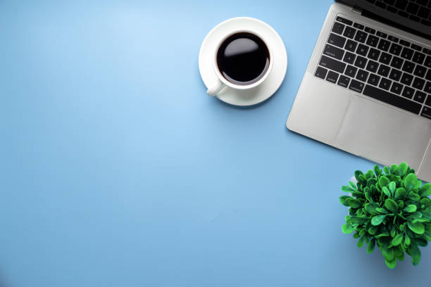 istock Flat lay, top view office table desk. Workspace with, laptop,office supplies, pencil, green leaf, and coffee cup on blue background. 1308193014