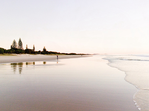 Horizontal landscape of a pastel sunrise at tranquil Belongil Beach, Byron Bay, north coast NSW