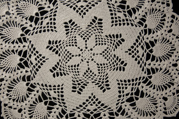istock lace napkin made of beige threads on a black background, crocheted, handmade 1308204649