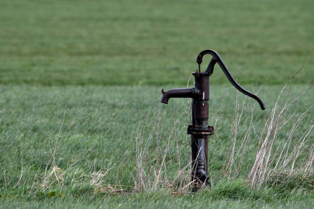 old fashioned hand water pump in a field close to oss, netherlands - groundwater imagens e fotografias de stock