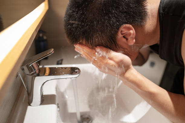 istock Young asian man washing his face with water 1308210214