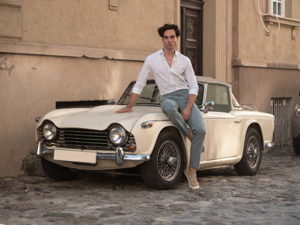 istock Young men posing by old classic car in town. 1308215276