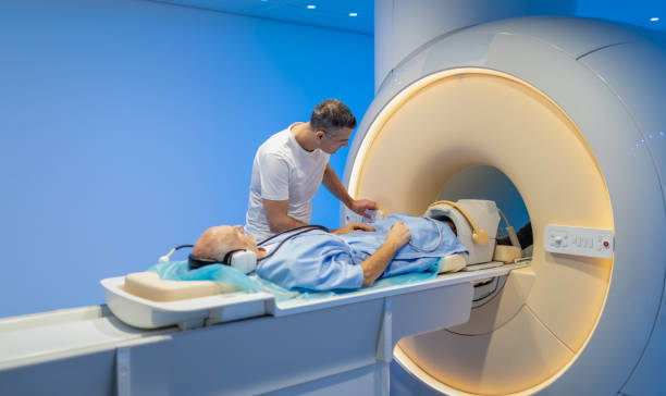 istock Male Radiologist Preparing Patient For MRI scan 1308221930