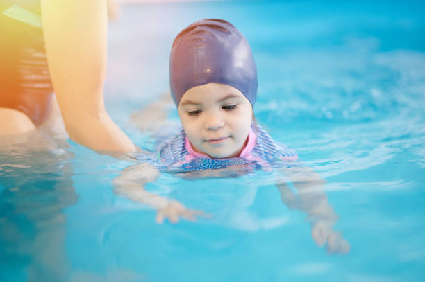 istock Kid playing in water and learning to swim 1308222942