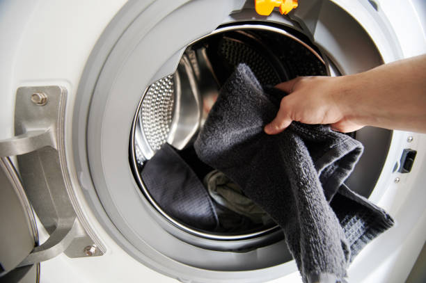 istock Hand put dirty cloth in washing machine 1308223204