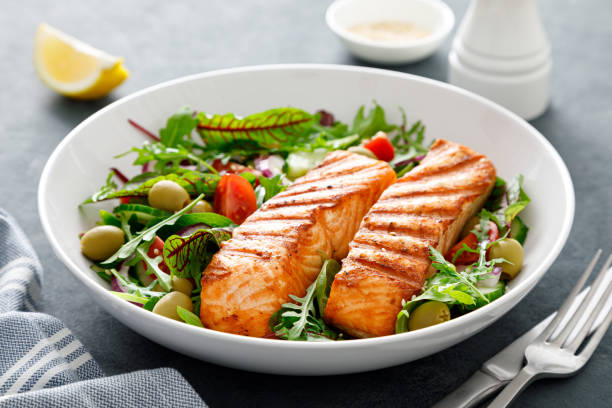 grilled salmon fillet and fresh vegetable salad. mediterranean diet. - fish plate dishware dinner imagens e fotografias de stock