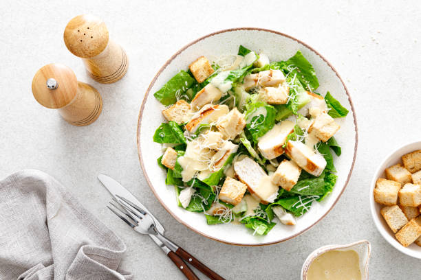 салат цезарь с сыром пармезан, куриным мясом на гриле и гренки - grilled chicken salad salad dressing food стоковые фото и изображения