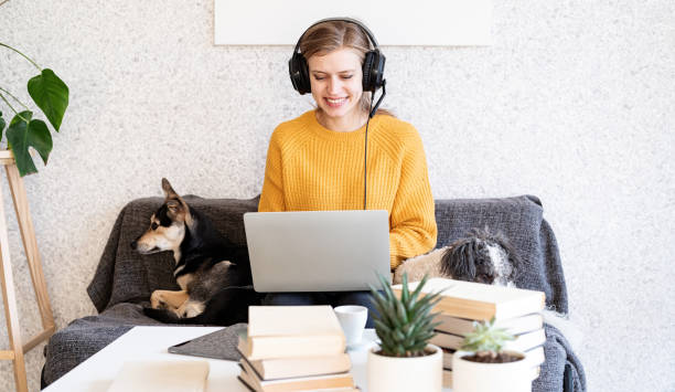 jovem sorridente em fones de ouvido preto estudando online usando laptop - dog school audio - fotografias e filmes do acervo