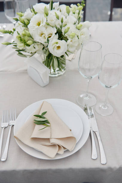istock Table setting with beige napkin on empty white plate, wineglasses and cutlery on table, copy space. Place setting at wedding reception. Table served for banquet 1308226006