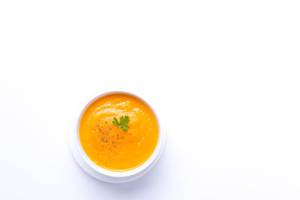 istock Bowl of carrot soup isolated on  white background with copyspace. Top view. 1308226928