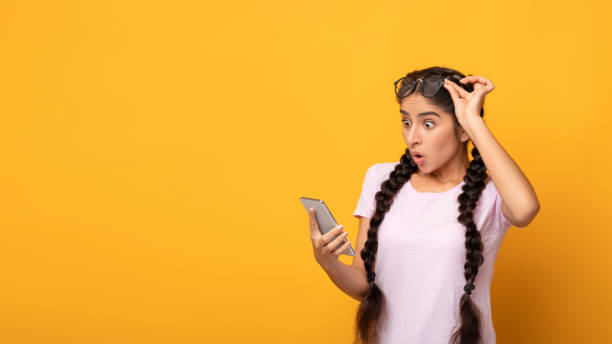 istock Excited indian woman using mobile phone, celebrating online win 1308228232