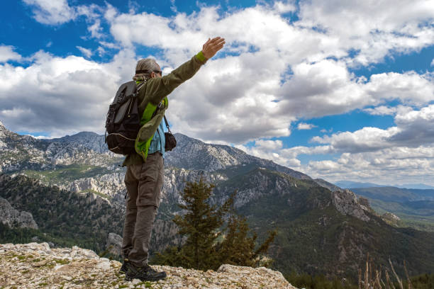 istock Cloudy valley view, mountains, 60 years old man in nature 1308228327