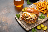 Homemade BBQ Pulled Pork burger with coleslaw, fries and beer