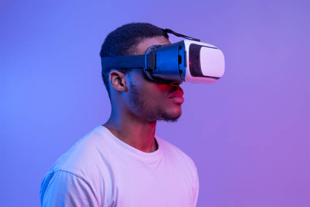 istock Black Man In VR Headset Standing In Neon Light Over Purple Background 1308228418