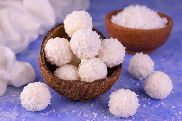 istock Coconut candies in a coconut shell on a blue front. Close-up. 1308229587