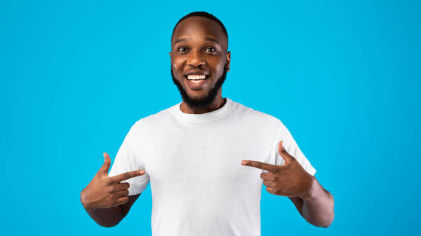 African Guy Pointing Fingers At Himself Posing Over Blue Background