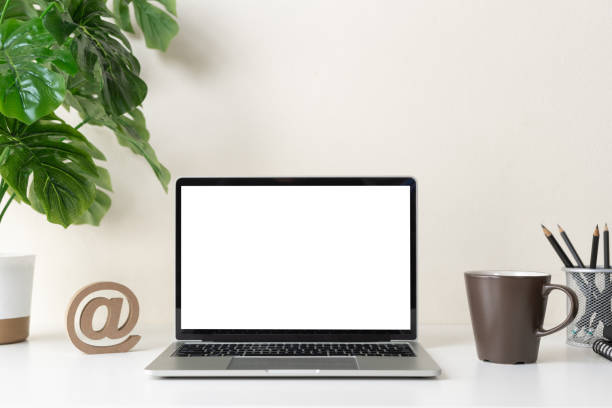 istock Laptop computer with blank screen for mockup on modern contemporary workspace desk with coffee cup and office supplies. Home office workplace. 1308232526