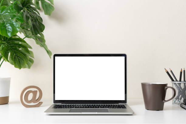 Laptop computer with blank screen for mockup on modern contemporary workspace desk with coffee cup and office supplies. Home office workplace. stock photo