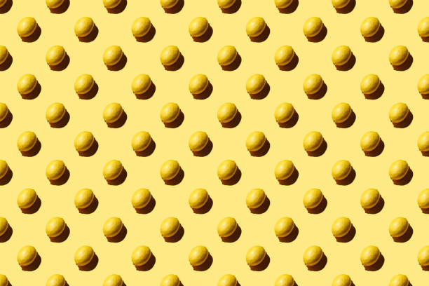 istock Trendy pattern made with fresh fruits on bright light yellow background. Minimal style with colorful paper backdrop. Colorful photo. Flat lay. Minimal creative concept. Food background. Lemons 1308235004