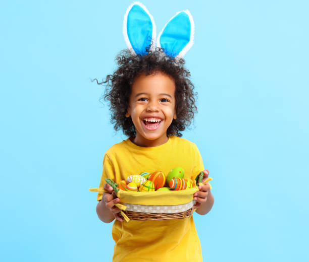 istock Cheerful ethnic kid holding Easter present in hands and laughing 1308236207