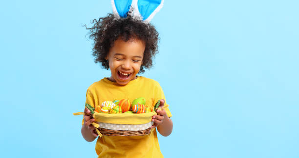 istock Cheerful ethnic kid holding Easter present in hands and laughing 1308236226