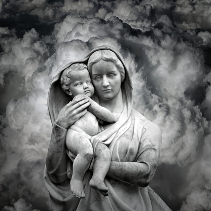 Vigin Mary mother statue carrying the saint baby Jesus in Clouds