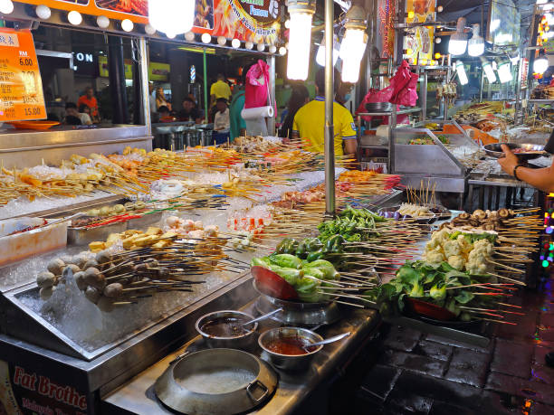 Traditional lok lok street food in South East Asia, Kuala Lumpur, Malaysia Kuala Lumpur, Malaysia - March 15, 2019: Jalan Alor street food Market. Food stalls with malaysian delicacy is Lok Lok. Popular tourist attraction. Selective focus, photo taken in low light at night traditional malaysian food stock pictures, royalty-free photos & images