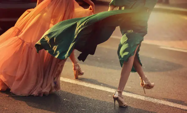 Photo of Women wearing elegant dresses, street style detail.