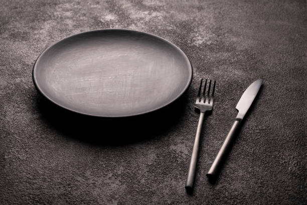 istock a frosted black empty plate and a knife and fork. a concept for the restaurant decor 1308240778