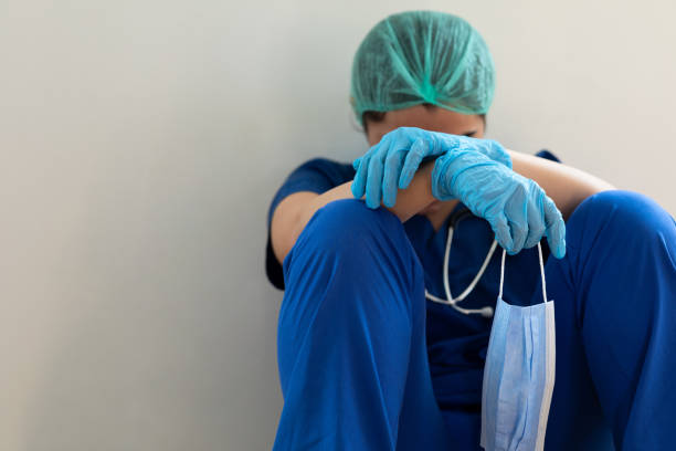 напряженный усталый медицинский работник, сидящий на полу - female nurse nurse scrubs female doctor стоковые фото и изображения