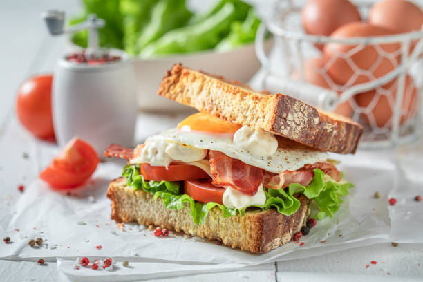 istock Tasty sandwich with egg, vegetables and bacon. British breakfast. 1308241693