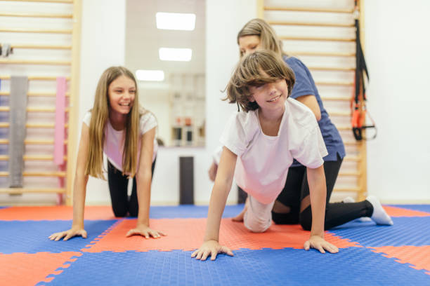 istock Physiotherapist helping young boy and girl exercise 1308241808