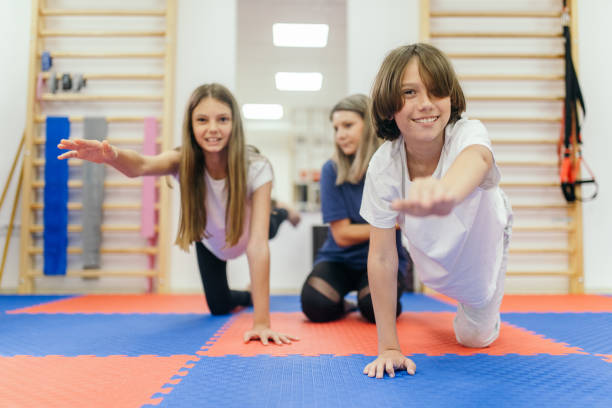 istock Physiotherapist helping young boy and girl exercise 1308241832