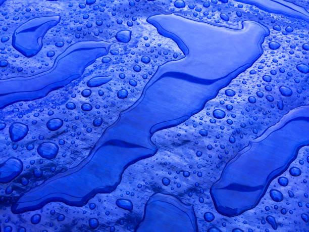 Droplets of rainwater on the blue tarp stock photo