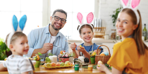 istock Happy family painting Easter eggs in light kitchen 1308245332