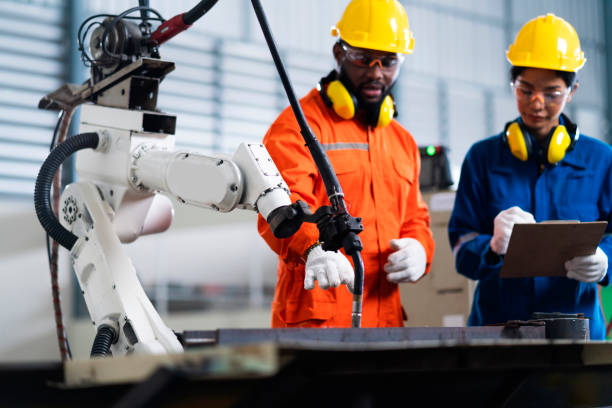 istock engineer cooperation male and female technician maintenance control relay robot arm system welding with tablet laptop to control quality operate process work heavy industry 4.0 manufacturing factory 1308247439