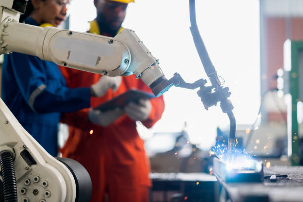 istock engineer cooperation male and female technician maintenance control relay robot arm system welding with tablet laptop to control quality operate process work heavy industry 4.0 manufacturing factory 1308247441