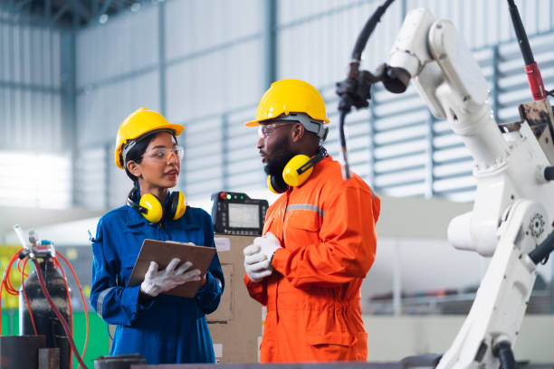 istock engineer cooperation male and female technician maintenance control relay robot arm system welding with tablet laptop to control quality operate process work heavy industry 4.0 manufacturing factory 1308247442