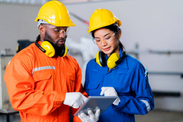istock engineer cooperation male and female technician maintenance control relay robot arm system welding with tablet laptop to control quality operate process work heavy industry 4.0 manufacturing factory 1308247454